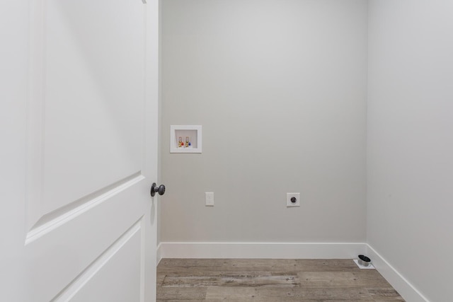 washroom featuring hookup for a washing machine, light hardwood / wood-style floors, and electric dryer hookup