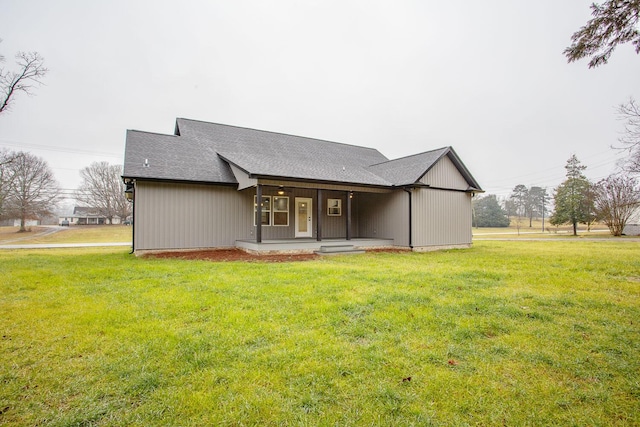 back of house with covered porch and a lawn