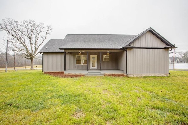 rear view of property featuring a porch and a lawn