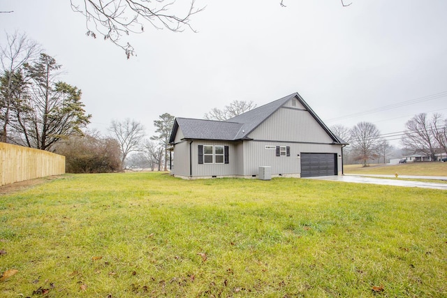 exterior space with a garage, a lawn, and central AC