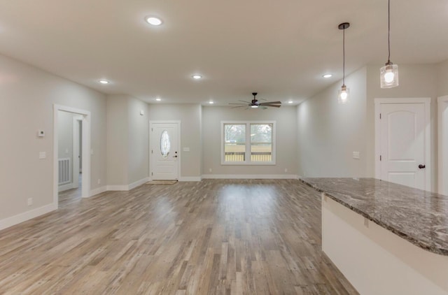 unfurnished living room featuring light hardwood / wood-style flooring and ceiling fan