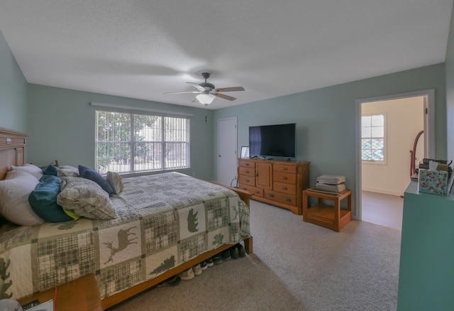 bedroom with ceiling fan and light carpet