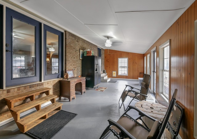 interior space with ceiling fan and wood walls