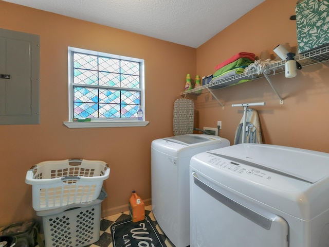 laundry area with electric panel, washer and dryer, and a textured ceiling