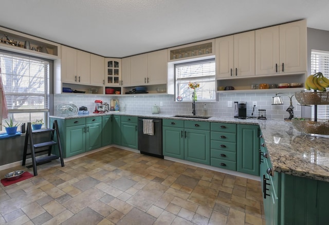 kitchen with sink, green cabinetry, dishwasher, light stone countertops, and backsplash