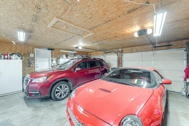 garage featuring a garage door opener and white fridge