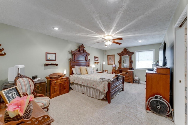 carpeted bedroom with ceiling fan and a textured ceiling