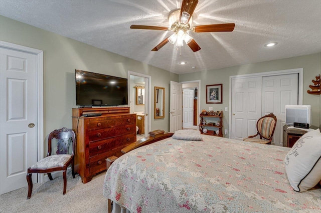 carpeted bedroom with ceiling fan, a textured ceiling, and a closet