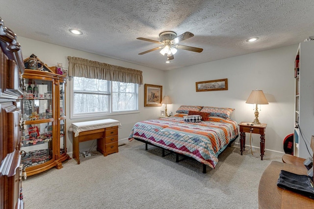 bedroom featuring a textured ceiling, carpet floors, and ceiling fan