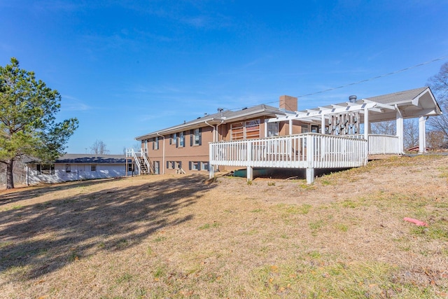 back of property featuring a deck and a lawn