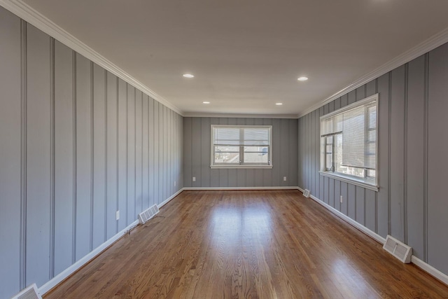 unfurnished room with hardwood / wood-style floors and crown molding