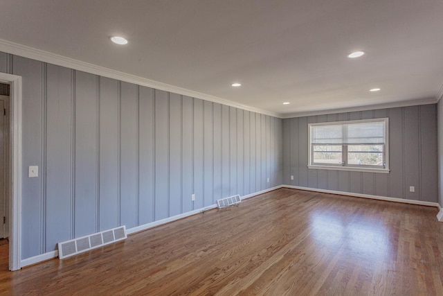 spare room with hardwood / wood-style flooring and crown molding