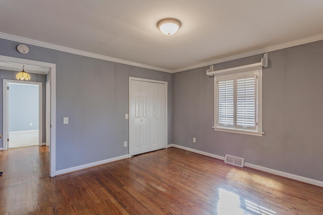 empty room with dark wood-type flooring and ornamental molding