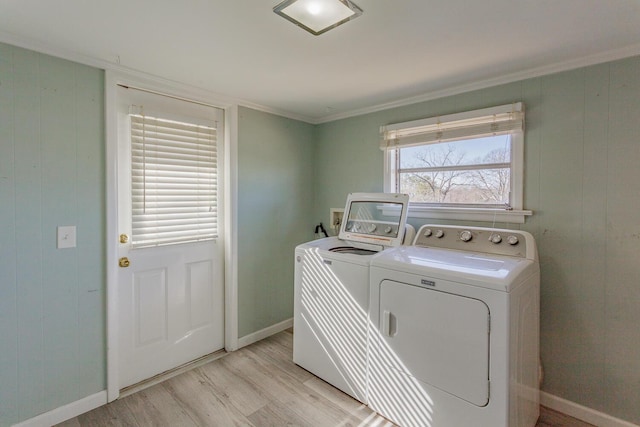 washroom featuring crown molding, light hardwood / wood-style floors, and washing machine and clothes dryer