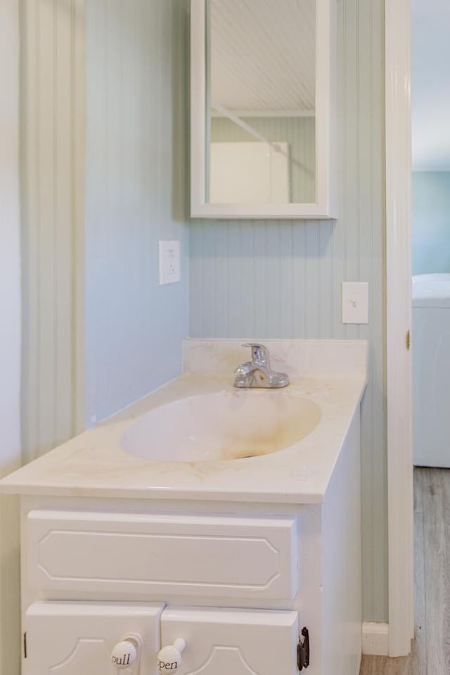 bathroom featuring washer / clothes dryer, vanity, and hardwood / wood-style flooring