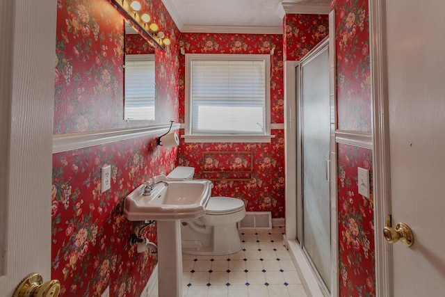 bathroom with ornamental molding, toilet, a shower with shower door, and sink