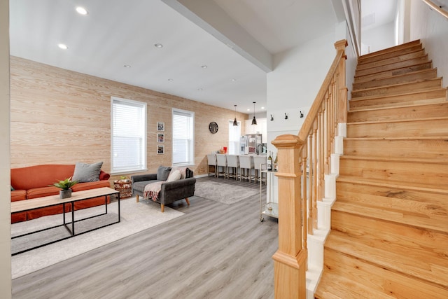 living room featuring beam ceiling and light wood-type flooring