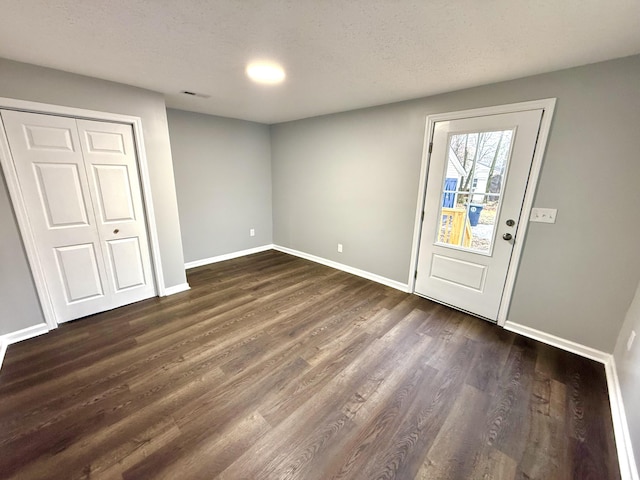 foyer featuring dark hardwood / wood-style flooring and a textured ceiling