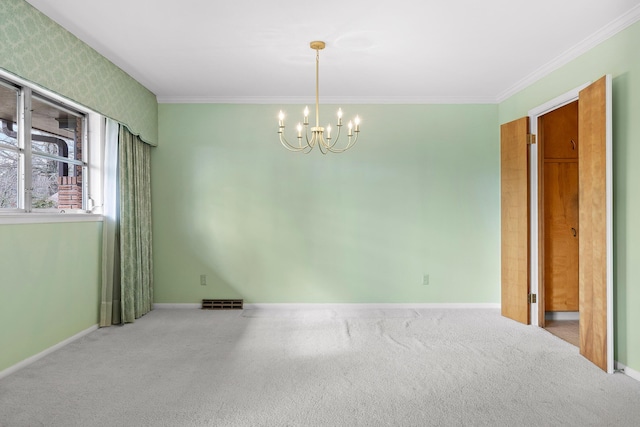 carpeted empty room with ornamental molding and a chandelier