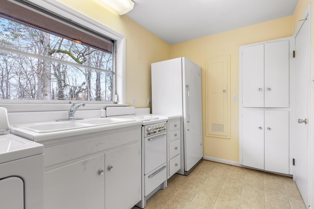 kitchen featuring white cabinetry, washer / dryer, sink, and white appliances