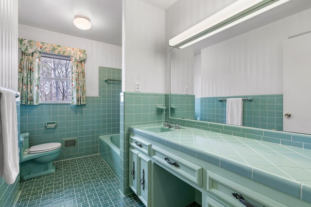 bathroom with tile patterned floors, vanity, toilet, and tile walls