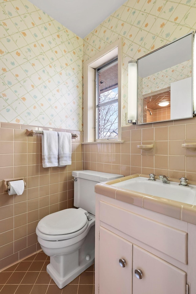 bathroom with vanity, tile walls, tile patterned floors, and toilet