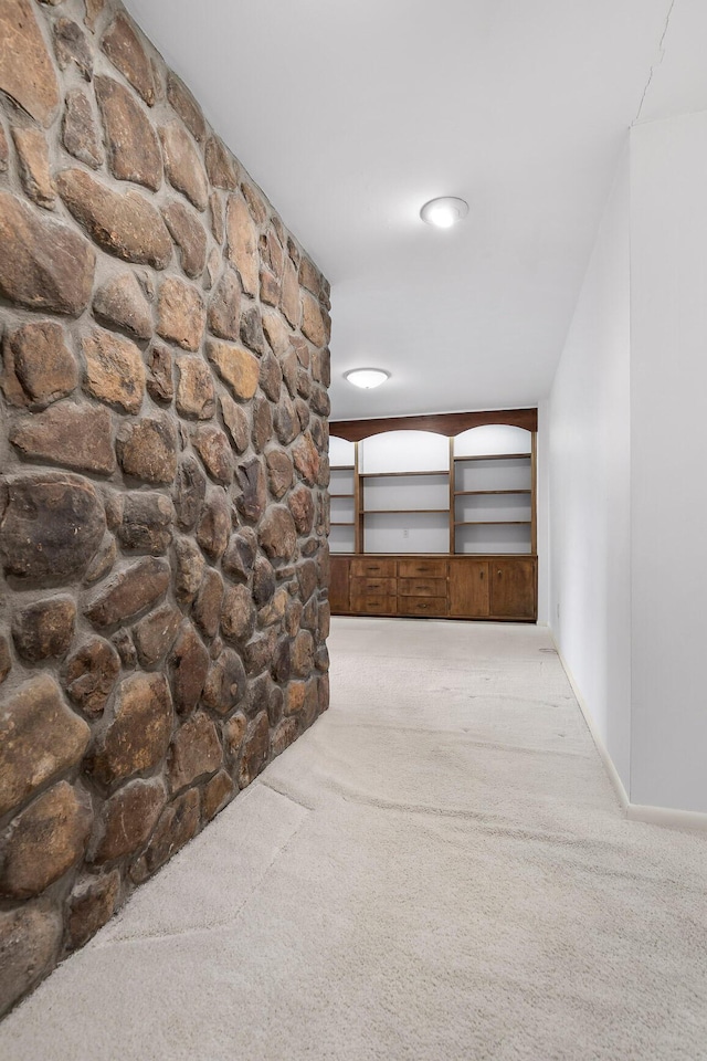 hallway featuring light colored carpet