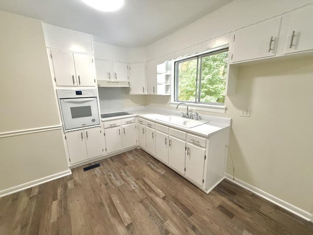 kitchen with sink, white cabinets, oven, dark hardwood / wood-style flooring, and black electric stovetop