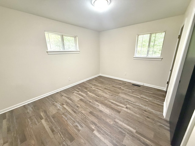 unfurnished room with wood-type flooring and a healthy amount of sunlight