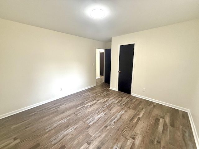 unfurnished bedroom with dark hardwood / wood-style flooring