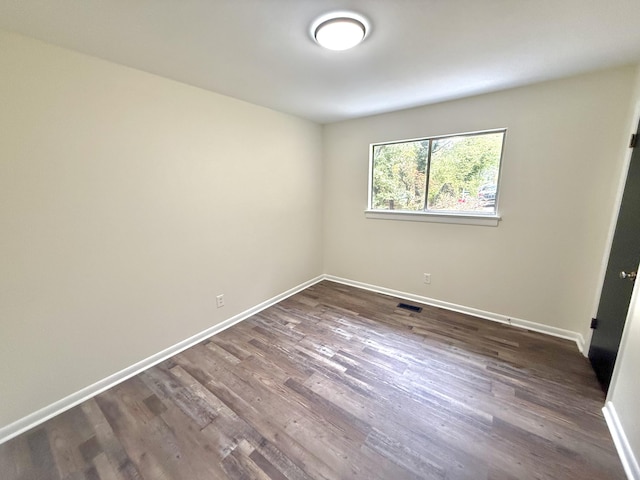 empty room with dark hardwood / wood-style flooring