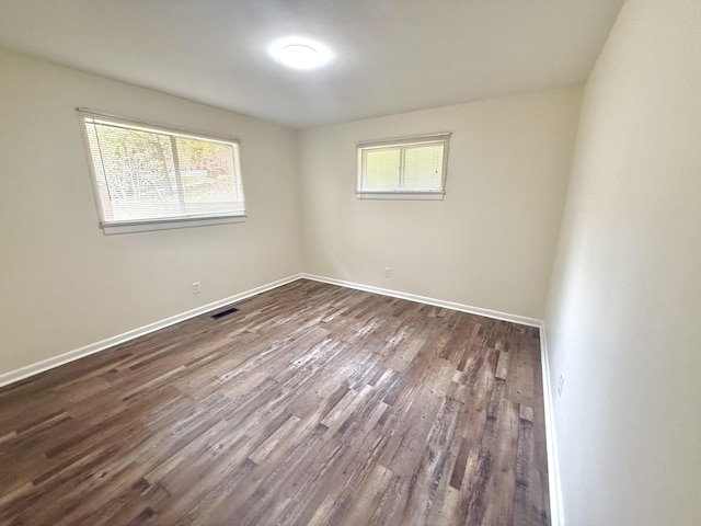 empty room featuring dark hardwood / wood-style floors and a healthy amount of sunlight