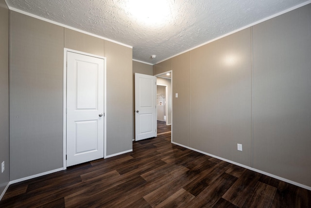 unfurnished bedroom with dark wood-type flooring, ornamental molding, and a textured ceiling