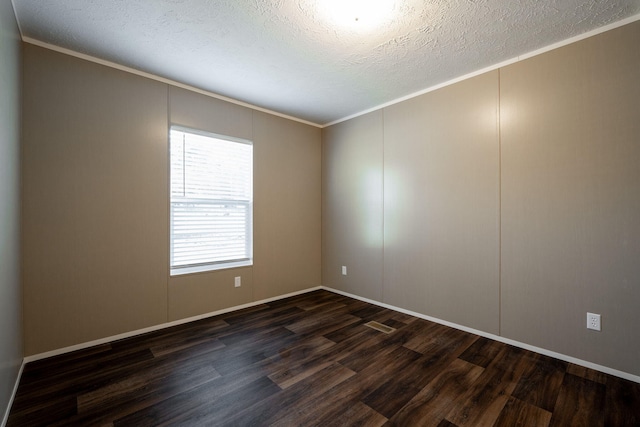 empty room featuring ornamental molding, dark hardwood / wood-style flooring, and a textured ceiling