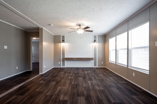 unfurnished living room with dark wood-type flooring, ceiling fan, ornamental molding, and a textured ceiling