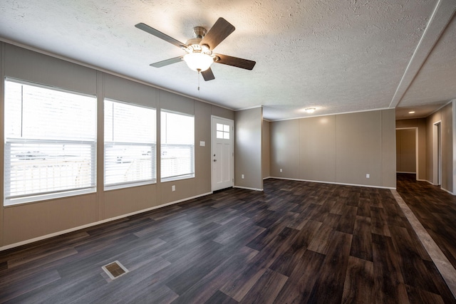 unfurnished living room featuring ceiling fan, dark hardwood / wood-style floors, and a textured ceiling