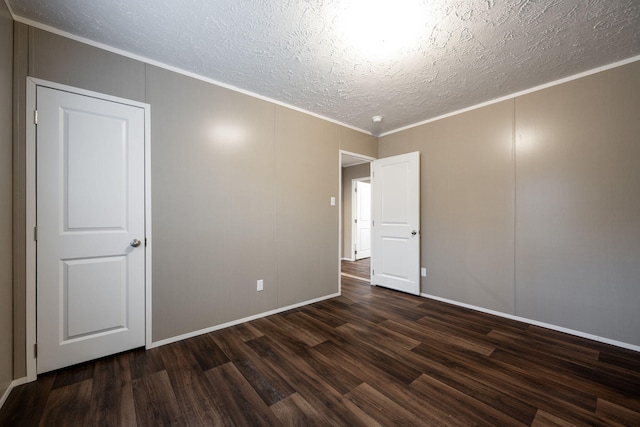 spare room with crown molding, dark hardwood / wood-style floors, and a textured ceiling