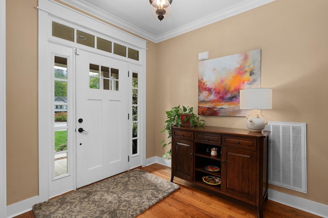 foyer entrance with ornamental molding and light hardwood / wood-style flooring