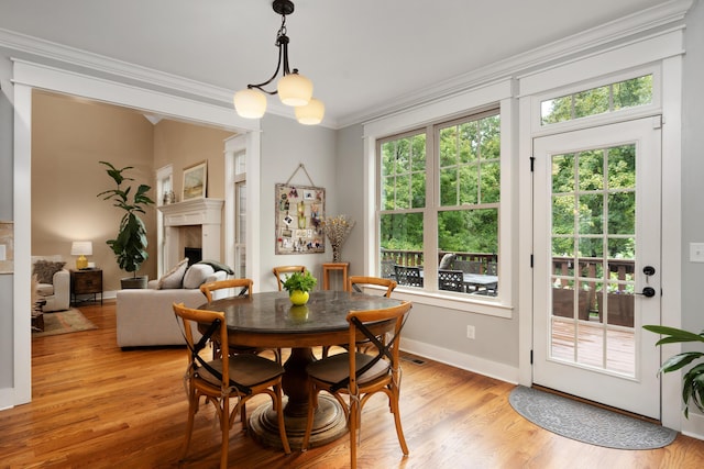 dining space featuring ornamental molding, a chandelier, and light wood-type flooring