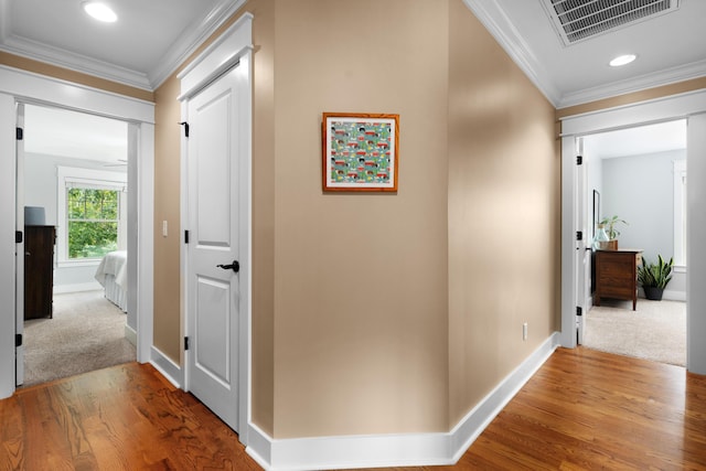 hallway featuring hardwood / wood-style flooring and crown molding