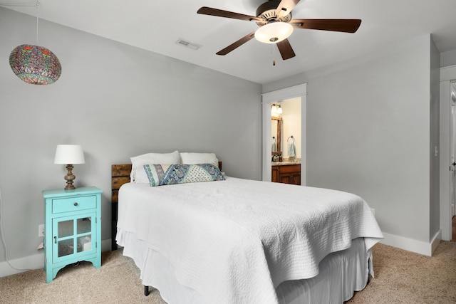 bedroom featuring light carpet, connected bathroom, and ceiling fan