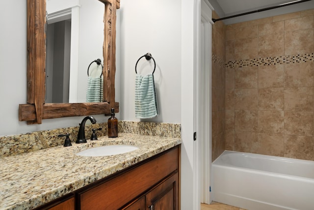 bathroom featuring tiled shower / bath combo and vanity