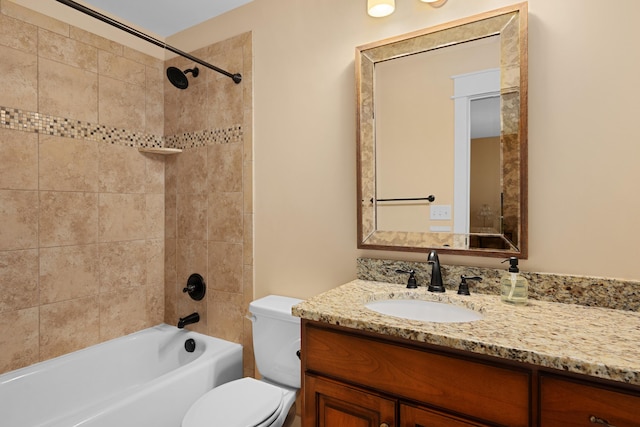 full bathroom with tiled shower / bath, vanity, and toilet