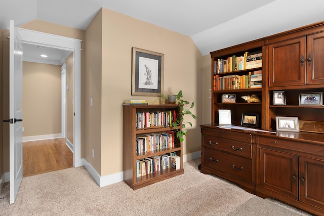 interior space featuring lofted ceiling and light carpet