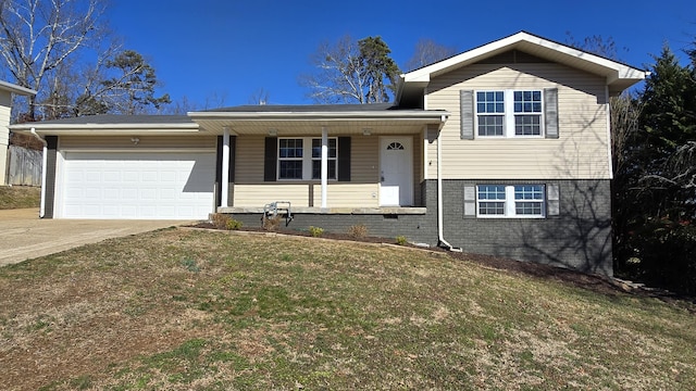 tri-level home with a garage, a front lawn, and covered porch