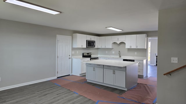 kitchen featuring a kitchen island, white cabinetry, sink, stainless steel appliances, and dark wood-type flooring