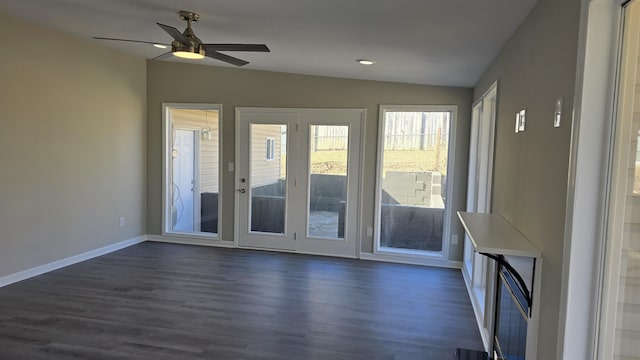 unfurnished living room featuring ceiling fan, dark hardwood / wood-style floors, and vaulted ceiling