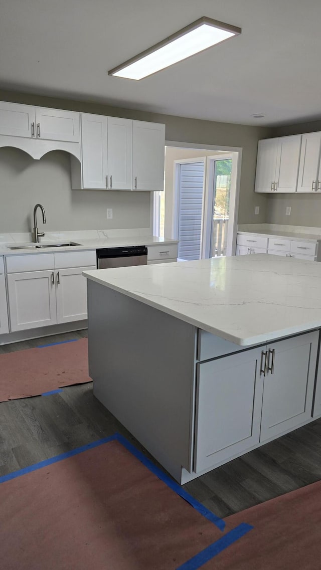 kitchen with dishwasher, sink, white cabinets, and light stone counters