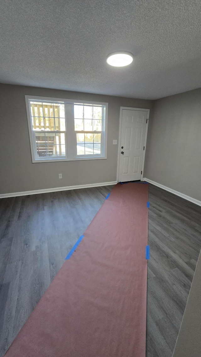 entrance foyer with a textured ceiling and dark hardwood / wood-style flooring