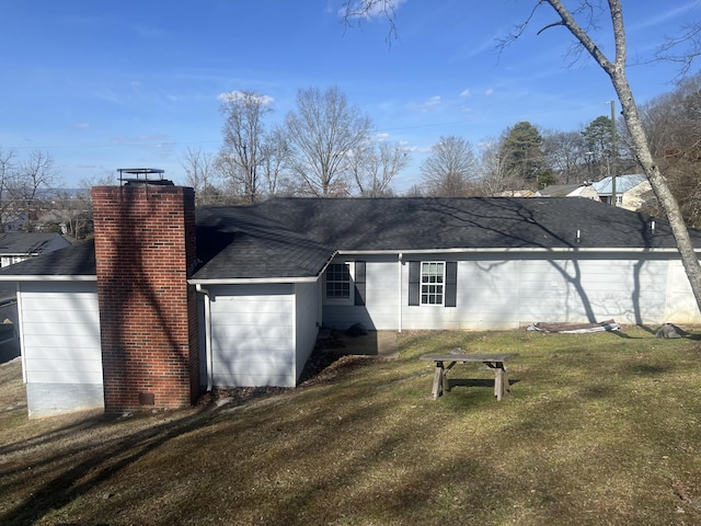 back of house featuring a garage and a lawn